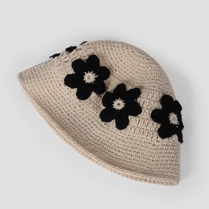 Détail du chapeau cloche beige crocheté main avec appliqués de fleurs en tricot