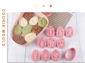 Detailed view of pink Easter cookie molds with rabbit and egg patterns on wooden table