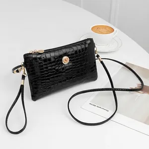 Elegant black alligator pattern crossbody bag with gold hardware and rhinestone detail