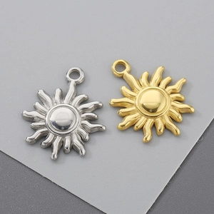 Detailed view of sun-shaped titanium steel pendants in gold and silver metallic finishes