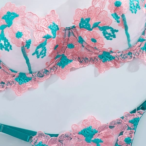 Close-up of pink and green floral embroidery on sheer mesh lingerie set with lace detail