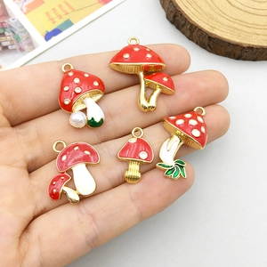 Handheld set of five colorful mushroom alloy charms with red enamel and pearl details