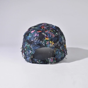 Detail of distressed floral baseball cap with vintage frayed edges and metal buckle