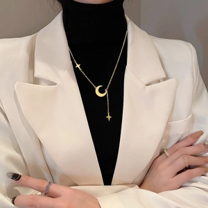 Minimalist gold moon and star tassel necklace in stainless steel worn by a model