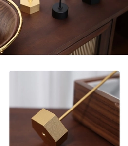 Detail of golden metal earring stand featuring a dark solid walnut wood base for jewelry