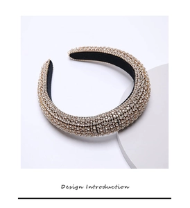 Detailed close-up of wide velvet headband with sparkling white rhinestones on gold base