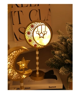 Macro shot of warm LED golden crescent moon and stars lamps on a wooden base