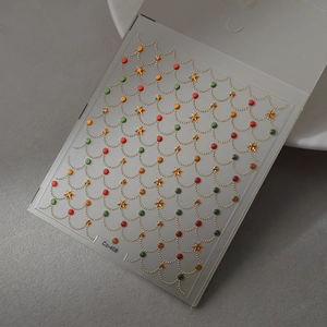 Macro detail of 5D gold embossed nail stickers with colorful beads and stars