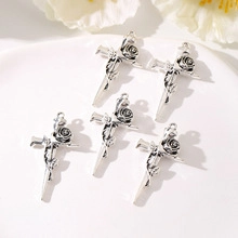 Detail view of four silver rose relief cross pendants for DIY jewelry crafting