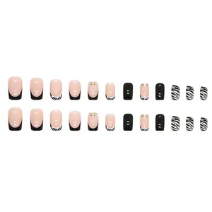 French tip press-on nails with zebra stripes, black patterns, and pearl rhinestone accents