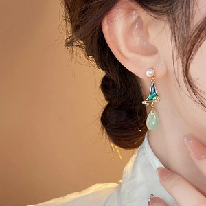 Macro shot of New Chinese style earrings with green enamel cloud motif and pearl drop