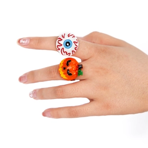 Detailed view of adjustable Halloween rings with pumpkin and eyeball designs on finger
