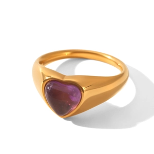 Close-up of a gold ring featuring a heart-shaped purple stone on a white background
