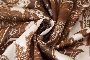 Gros plan détaillé du tissu imprimé paisley avec texture de soie marron et caramel