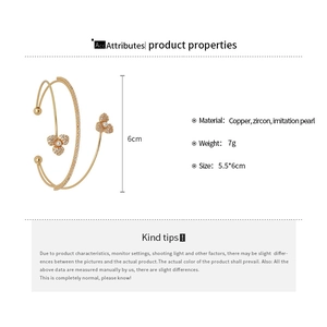 Detailed view of multilayer zircon flower bangle with white pearls and gold finish