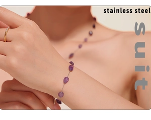Detail of bohemian stainless steel set featuring irregular purple natural stones on a model