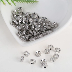 Macro shot of silver rondelle beads with inlaid zircons for DIY jewelry making
