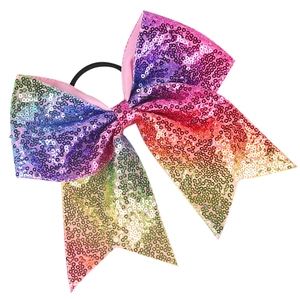 Vue détaillée d'un nœud à paillettes arc-en-ciel avec un élastique noir pour les filles