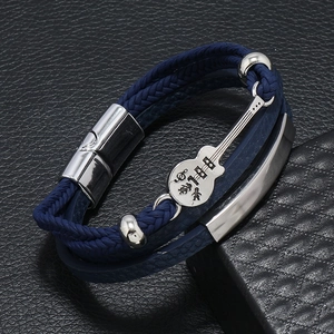 Macro shot of blue braided leather bracelet featuring a silver guitar pendant and musical notes