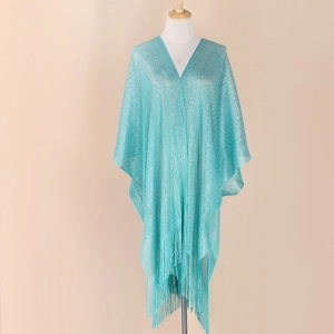 Detail of light blue knitted shawl showing the intricate weave and hanging tassels