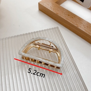 Detail shot showing a 5.2cm medium hollow semicircle hair claw clip in marble acetate