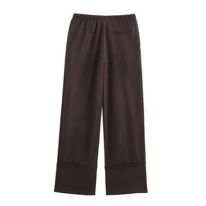Detail of dark brown linen-style wide leg pants featuring an elastic waist and back pocket