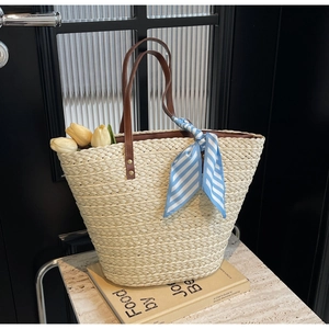 Straw woven tote bag in cream white with a blue striped scarf and tulip decoration on books