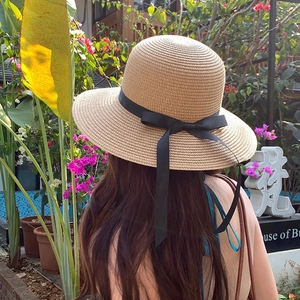 Summer wide brim straw hat with black ribbon bow for outdoor sun protection and beach style