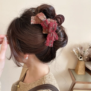 Detail of red-brown tweed bow hair claw clip worn on hair with elegant French retro style