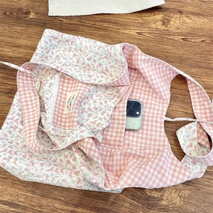 Detail of floral tote bag showing lace-trimmed inner pocket and reversible fabric texture