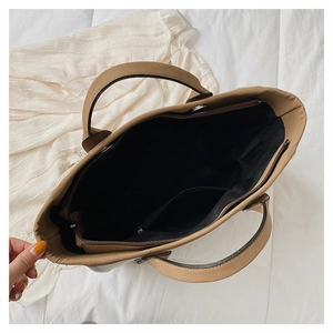 Top view of brown bucket bag interior showing spacious black lining and metal zipper