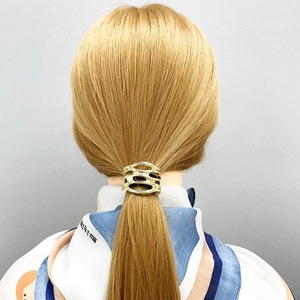 U-shaped gold metal ponytail cuff with pearl accent and hollow design on model