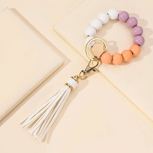 Beaded keychain bracelet with wooden beads, gold hardware and white faux leather tassel