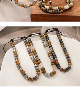 Detail of natural stone beaded bracelets with adjustable silver metal clasp on a white plate