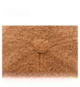 Macro shot of brown lambswool baseball cap fabric with textured curly fleece detail