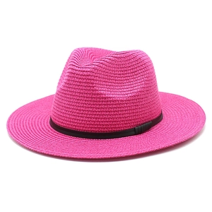 Detail of rose pink straw fedora hat featuring woven texture and black leather band