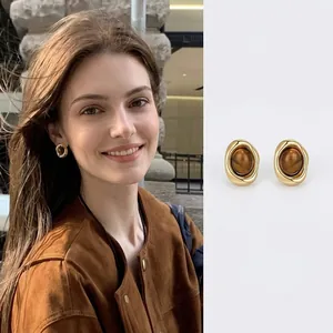 Vintage gold oval stud earrings with tiger eye stone featuring an elegant geometric design