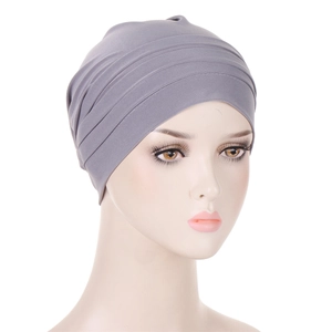 Detail of the elastic gray pleated turban cap fabric shown on a model head stand