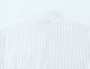 Detailed close-up of brown vertical stripes on white woven cotton shirt fabric