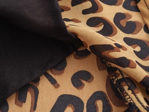 Detailed close-up of leopard print and solid black fabric stitching with visible textures