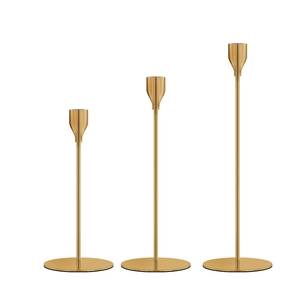Three gold metal candle holders of different heights for elegant wedding table decor