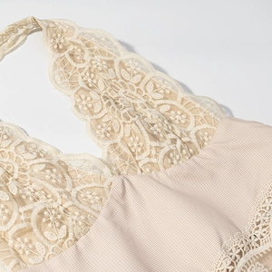 Détail du patchwork en dentelle beige et tissu à carreaux sur une robe dos nu col en V