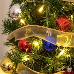 Close-up of a 55cm mini Christmas tree with colorful ornaments, LED lights, and golden ribbons
