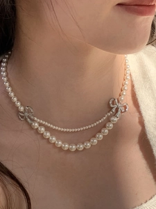 Gros plan d'un collier de perles double épaisseur avec nœuds en cristal sur cou