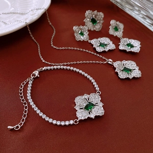 Detail view of emerald-cut green zircon flower jewelry set with silver tennis chain style