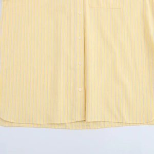 Detailopname van geel en wit gestreept poplin overhemd met witte ronde harsknopen
