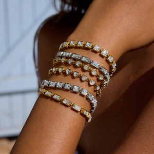 Minimalist 18K gold and silver tennis bracelet set with multiple gemstone cuts on wrist