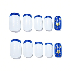 Close-up of square press-on nails with navy blue French tips and golden star patterns