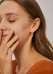 Detail of gold-plated U-shaped earrings with micro-set zircon on model for daily wear