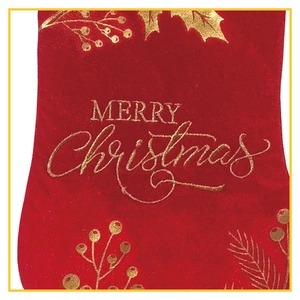 Close-up of red velvet Christmas stocking with golden Merry Christmas text and holly leaf